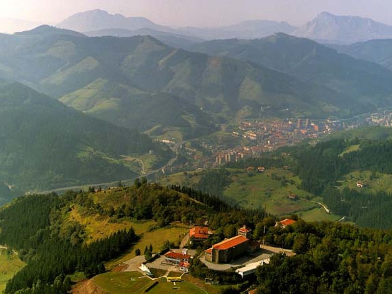 Argazkia: Arrateko eliza eta ingurua airetik ikusita eta barren-barrenean Eibar. 1990 inguruko argazkia (Paisajes Españoles, Eibarko Udal Artxiboa).
